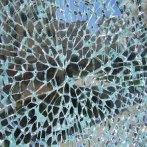 Close-up van een ruit met een dicht netwerk van thermische glasscheuren