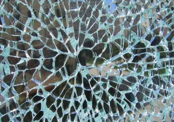 Close-up van een ruit met een dicht netwerk van thermische glasscheuren