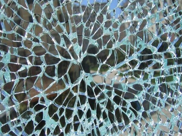 Close-up van een ruit met een dicht netwerk van thermische glasscheuren
